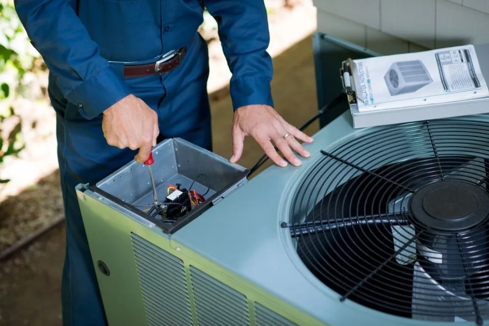 An AC technician operating a new AC unit diagnostics test.