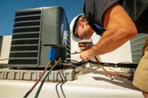 An HVAC technician installs a component to repair the unit.