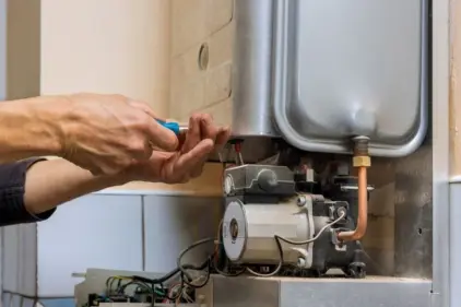 An HVAC expert tightens a screw on a new system component.