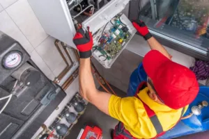An HVAC expert working on the electronics portion of a new furnace installation.
