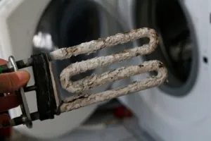 An HVAC repairman is displaying an old worn out heating coil element.