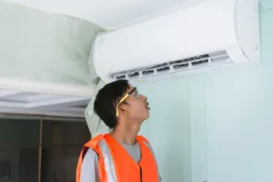 An AC repair expert looks at the control box of a new unit after installation.