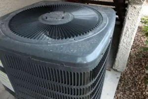 An older AC system sitting outside about to be replaced.
