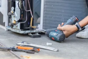 An HVAC repair technician working on a unit. 