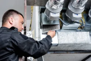 An HVAC specialist is replacing a filter cartridge in a furnace replacement.