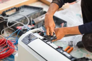 An HVAC repair expert fixes an internal thermostat on an older unit. 