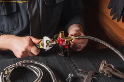 An HVAC specialist assembles a gas line valve connection.