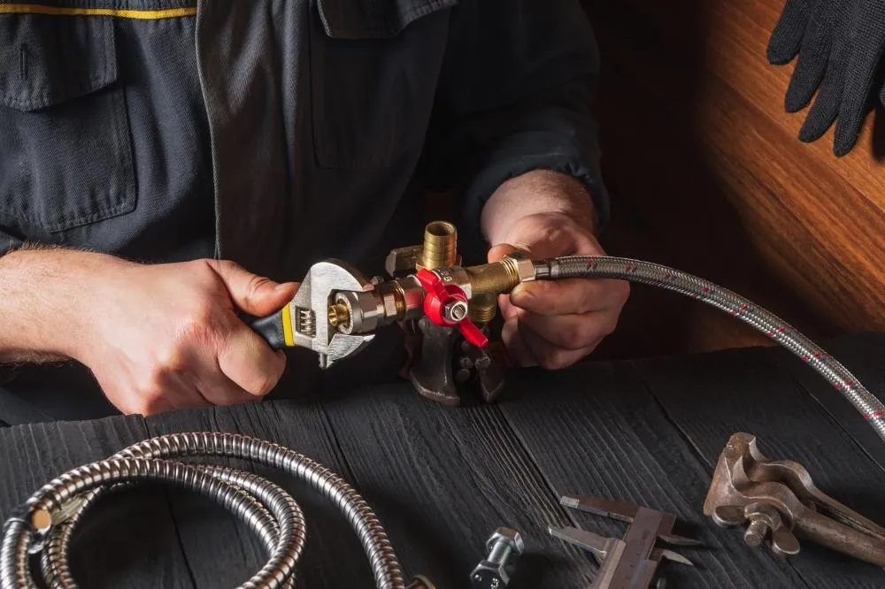 An HVAC specialist assembles a gas line valve connection.
