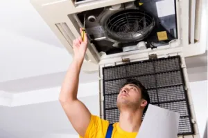 An HVAC repair expert tightens a screw to install a new boiler in the unit.